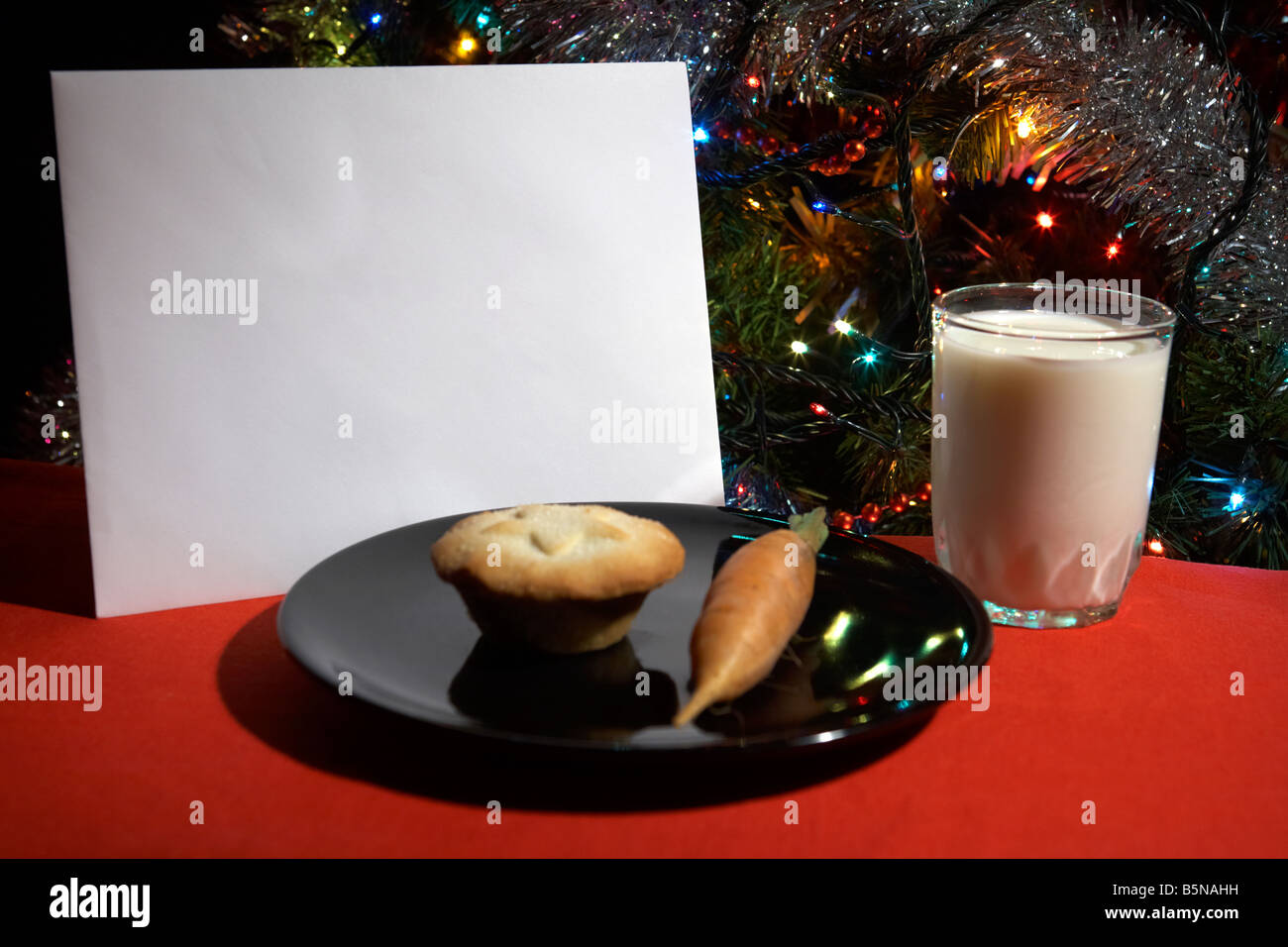 Brief an Heiligabend mit Mince Pie Karotte und ein Glas Milch vor Weihnachtsbaum ausgelassen Stockfoto