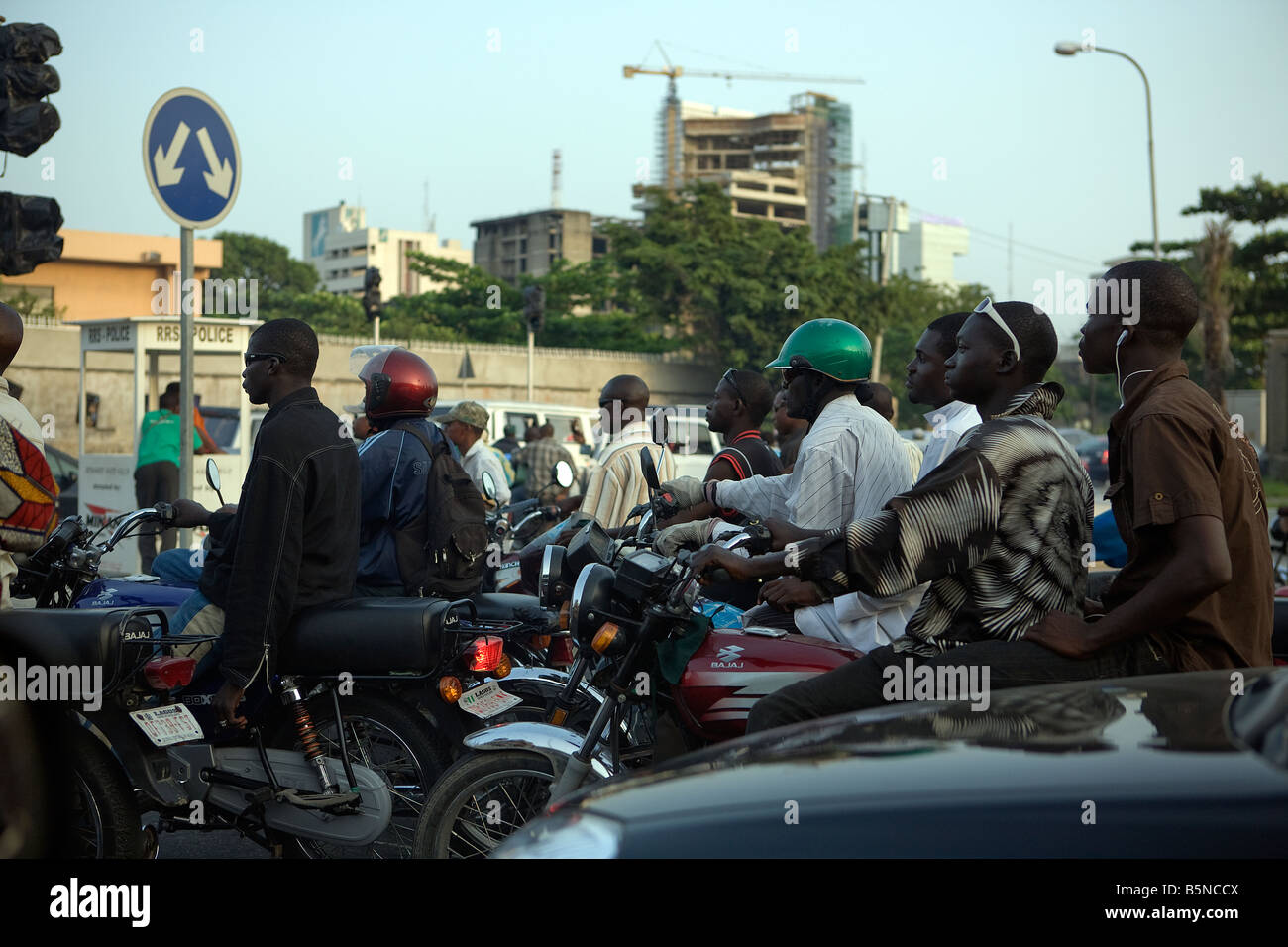 Viele Männer mit Motorrädern nach Hause nach einem Tag bei der Arbeit durch die Stadt von Lagos, Nigeria, an einem sonnigen Abend Stockfoto