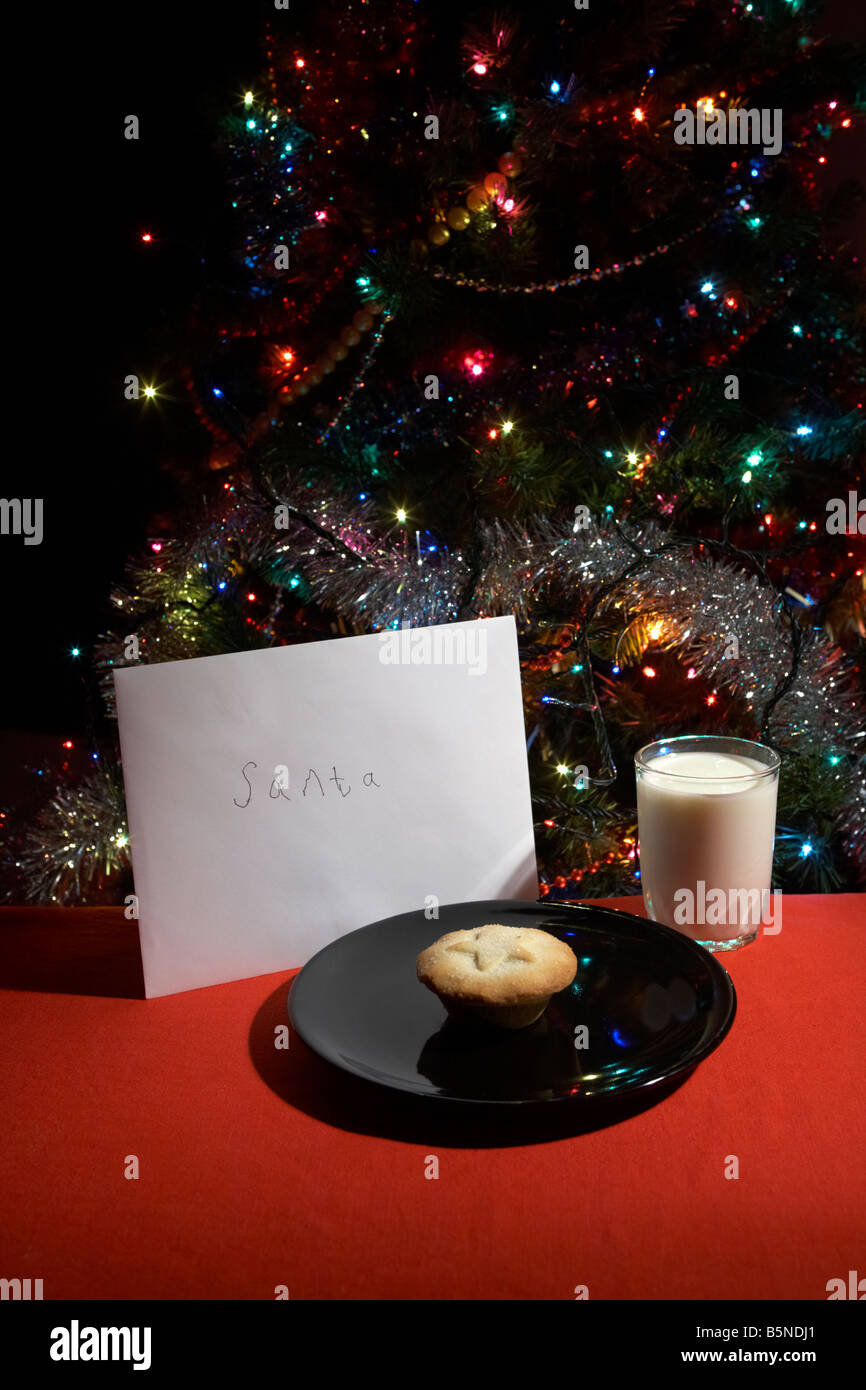 Kinder-Brief an den Weihnachtsmann am Heiligabend mit Mince Pie und ein Glas Milch vor Weihnachten Baum ausgelassen Stockfoto