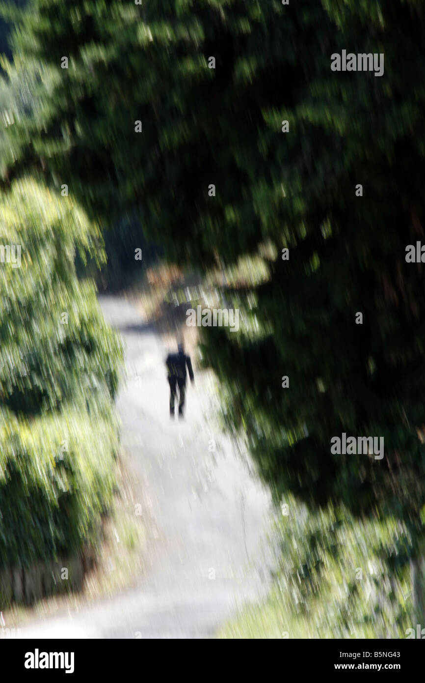 ein Alter Mann zu Fuß auf ländlichen Landstraße Stockfoto