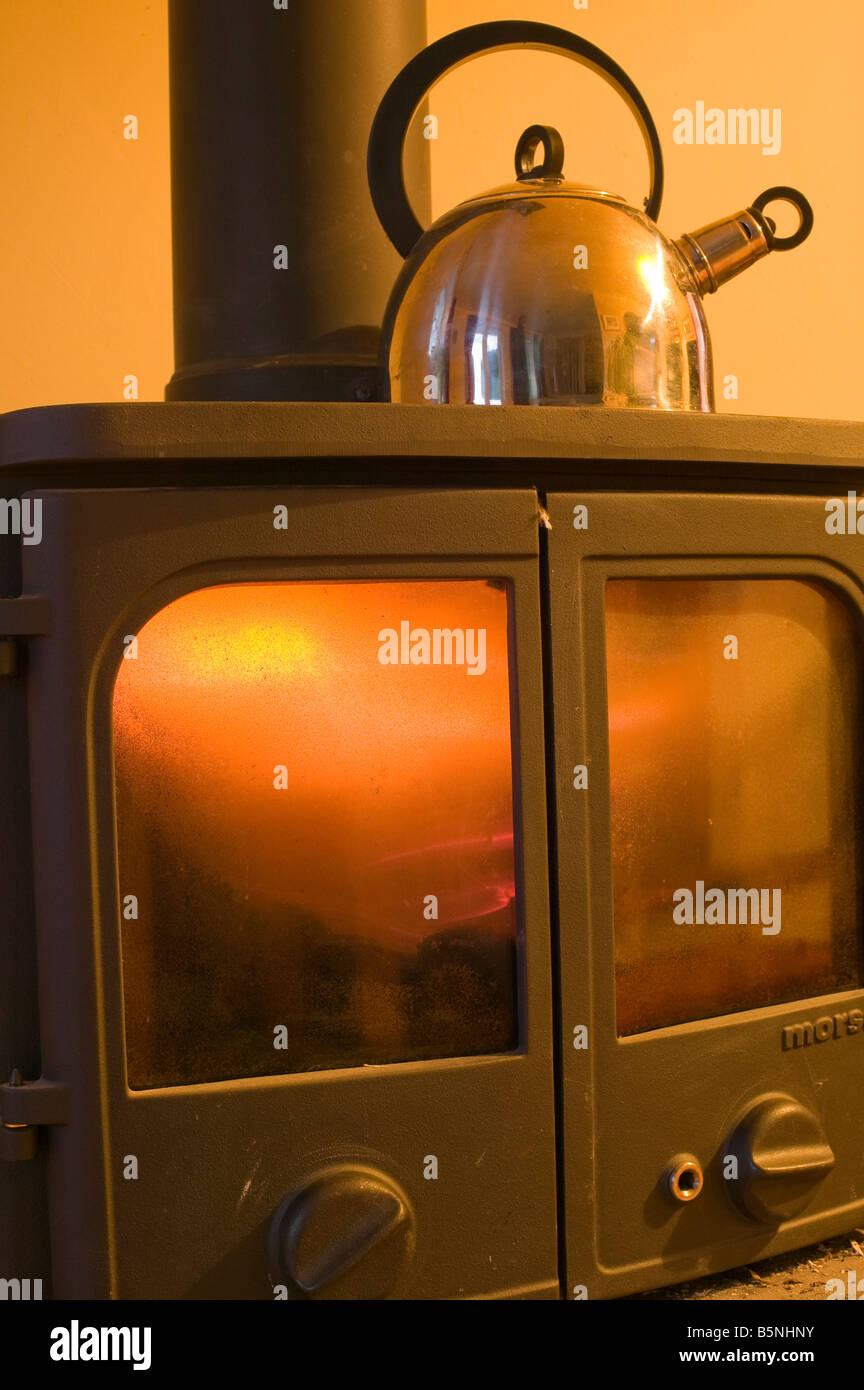 Einen Wasserkocher auf einem Holzofen kochen ist eine CO2-neutrale Art zu heizen Stockfoto