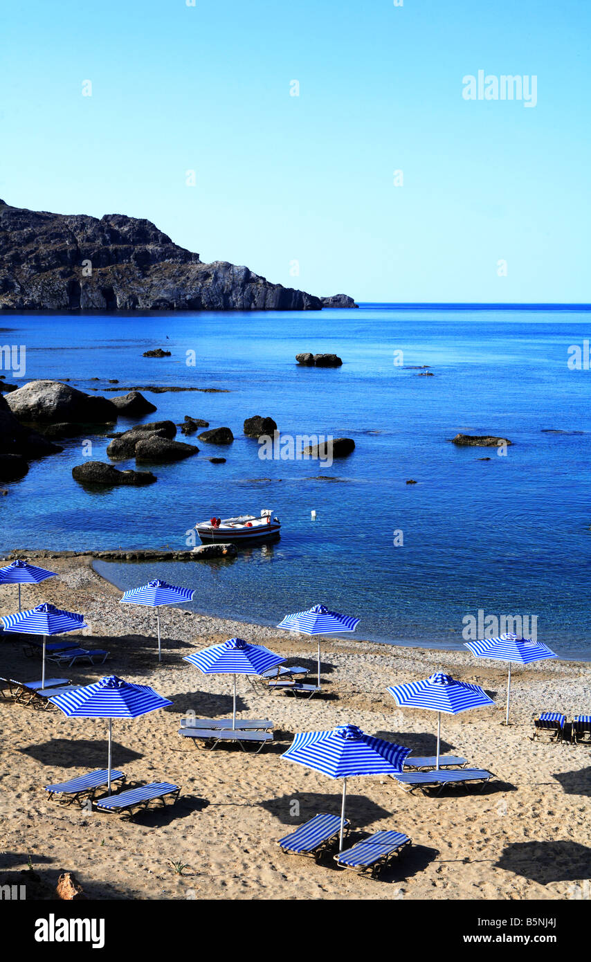 Sonne-Sonnenschirme, Sonnenliegen und einem kleinen Fischerboot auf der westlichen Seite von Plakias südlichen Kreta Griechenland Stockfoto