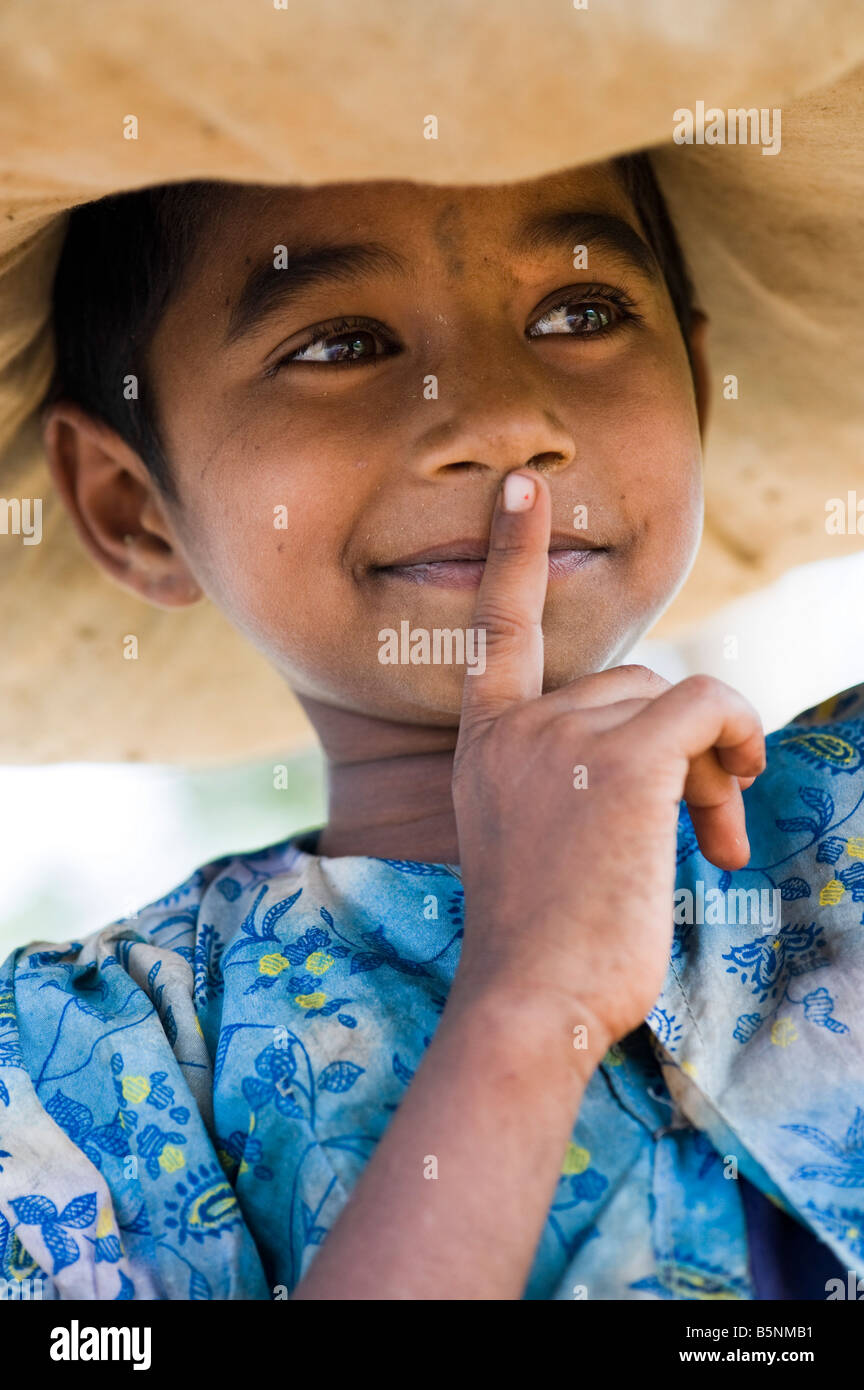 Armer junge Inderin Wäsche in einem Bündel auf dem Kopf tragen. Andhra Pradesh, Indien Stockfoto