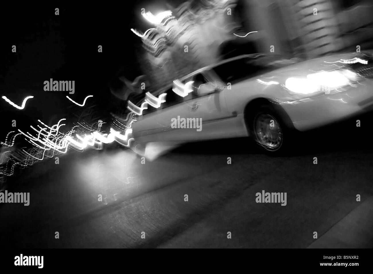 Eine abstrakte Unschärfe einer weißen Limousine in der Stadt in der Nacht mit Lichtspuren Stockfoto