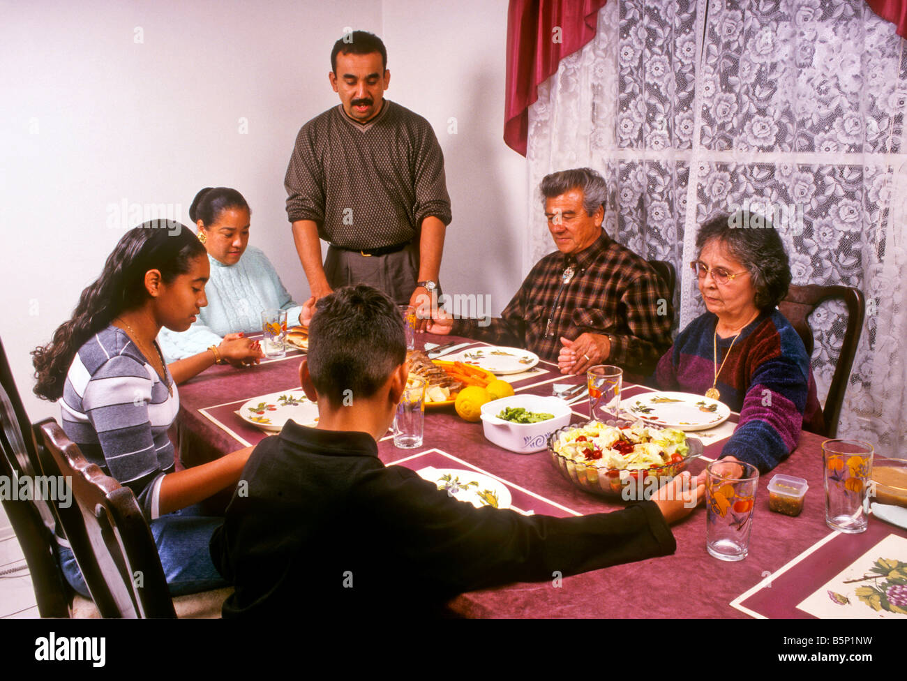 Hispanische Familie segnet Essen vor dem Festessen. Stockfoto