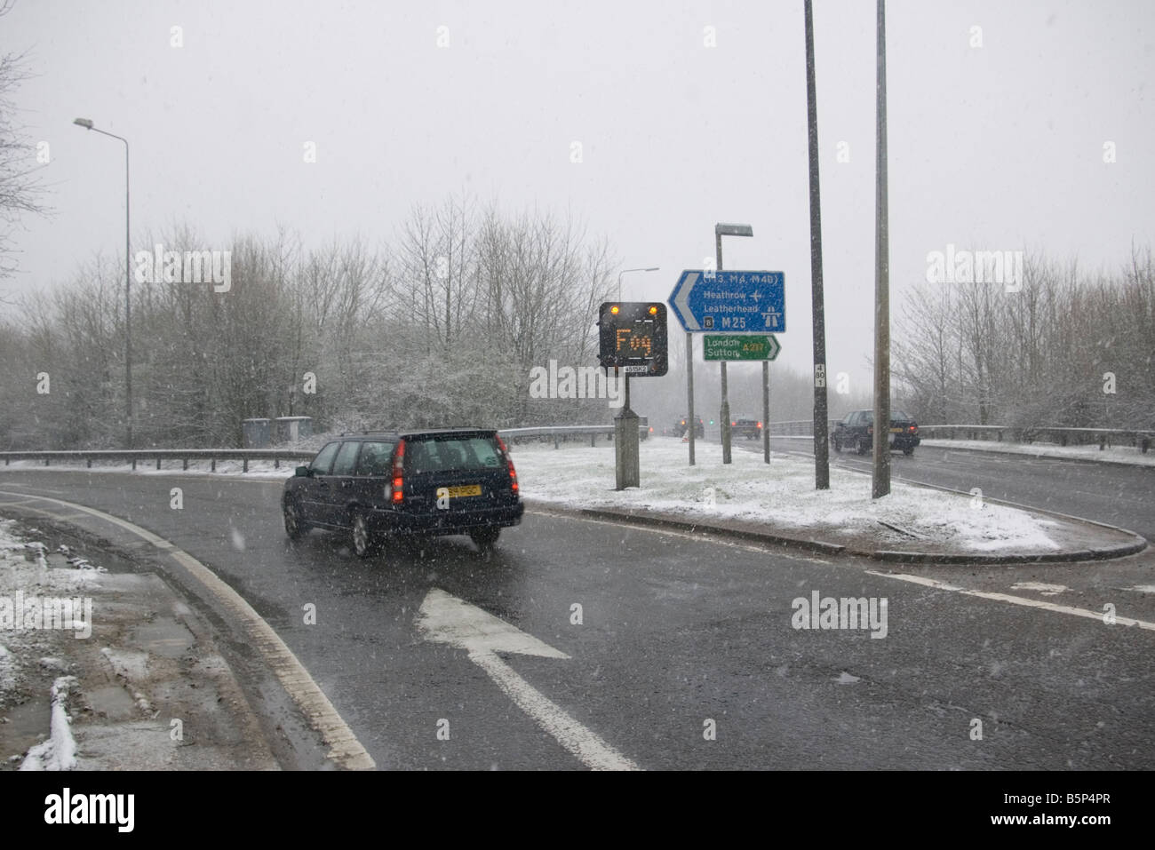 Auto fahren in Schneeregen und Schnee schlechte Voraussetzungen mit einem Nebel Zeichen angezeigt Stockfoto