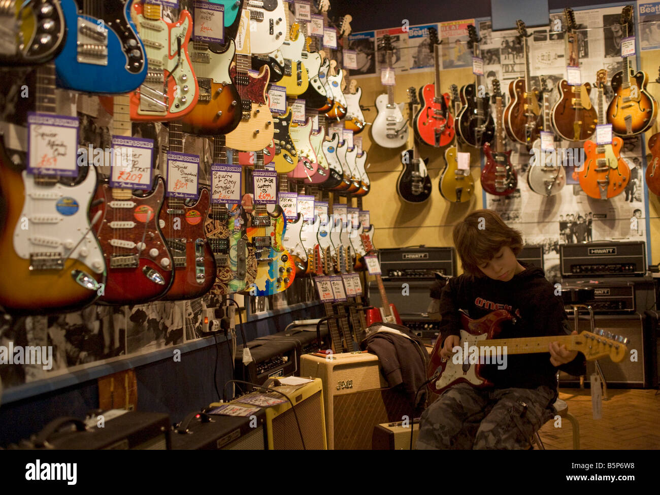 Ein 10 jähriger Junge spielt eine verstärkte elektrische Fender Stratocaster-Gitarre bei Regent Sound auf 4 Denmark Street, Tin Pan Alley Stockfoto