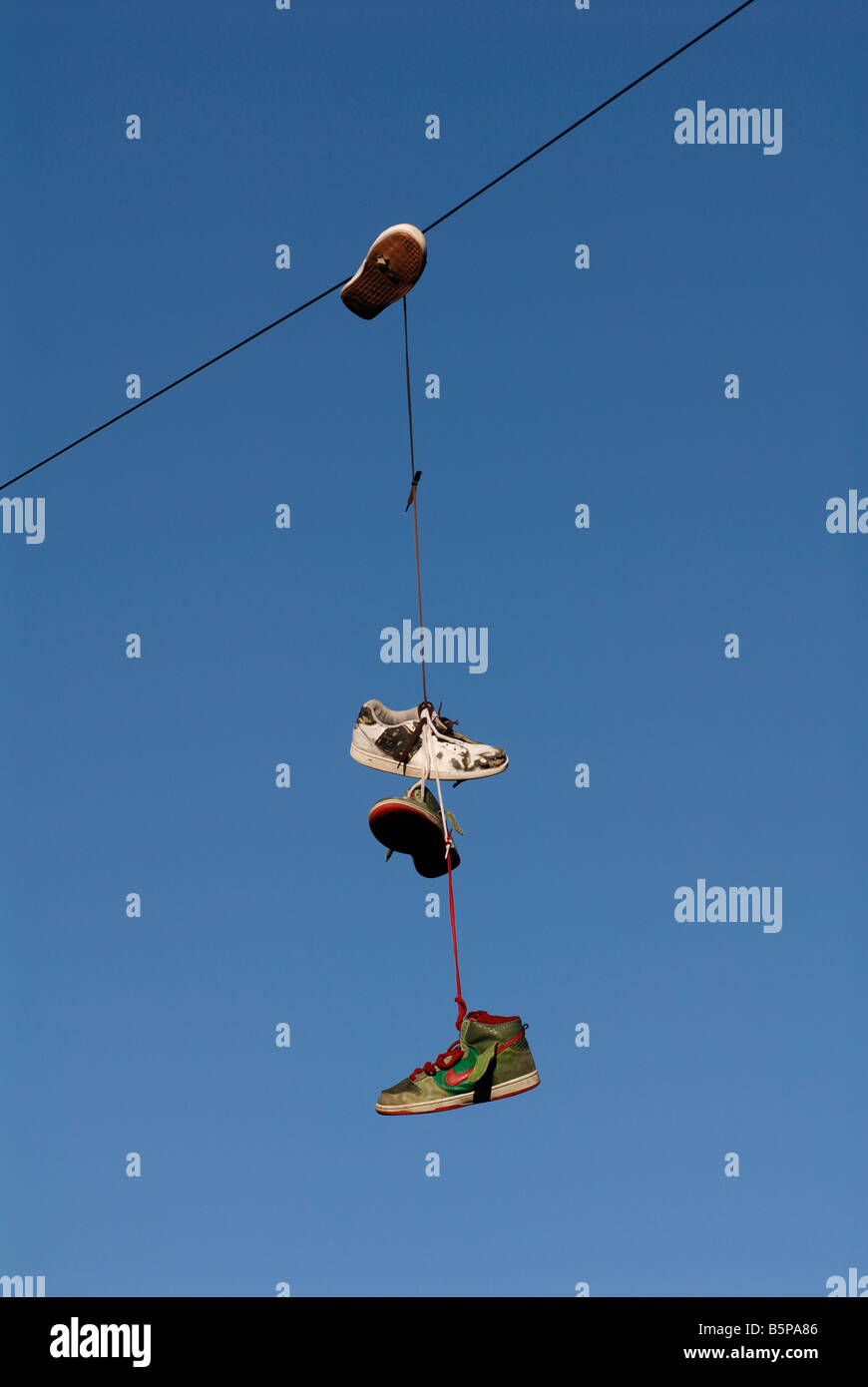 Alte Schuhe hängen aus dem Telefondraht Stockfoto