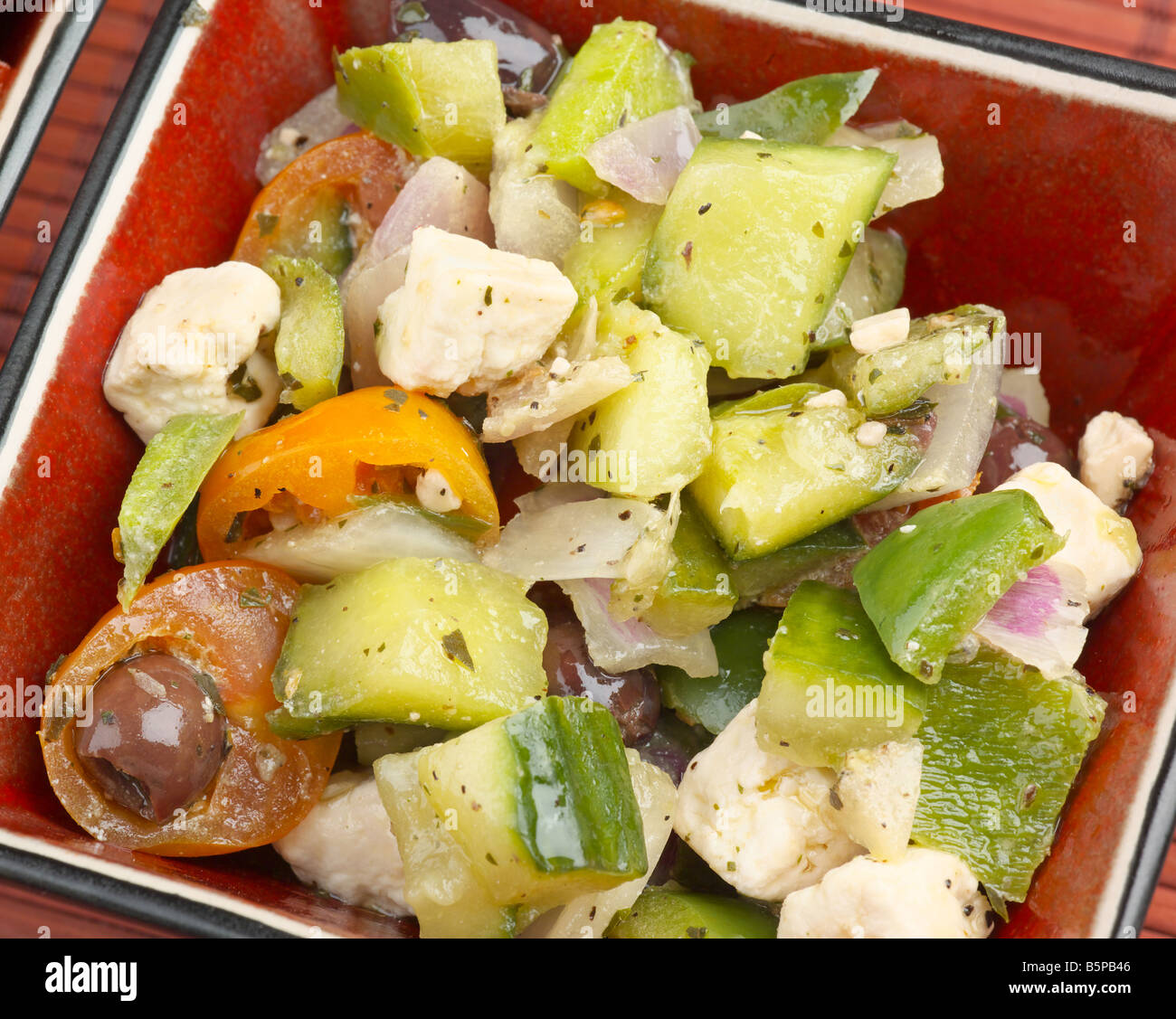 Griechischer Salat mit Feta-Käse-Gurken-Tomaten-Oliven und Zwiebeln in Olivenöl Stockfoto