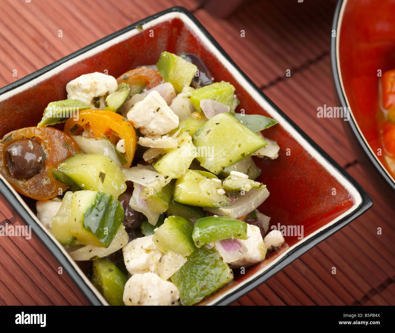 Griechischer Salat mit Feta-Käse-Gurken-Tomaten-Oliven und Zwiebeln in Olivenöl Stockfoto