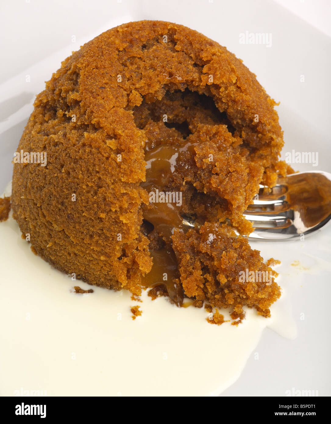 Dampf-Pudding mit Toffee-Sauce-Füllung und Sahne Stockfoto