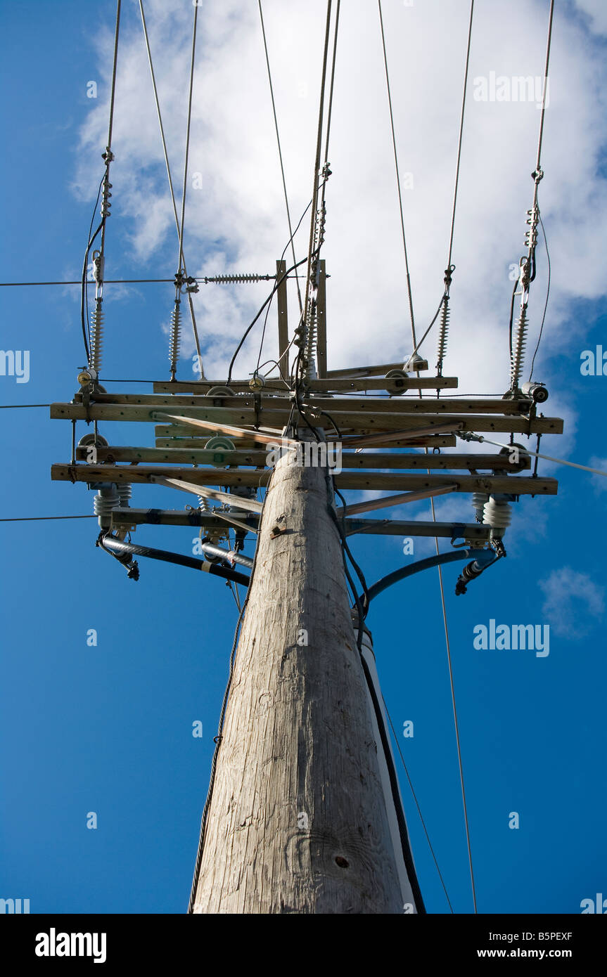 Heavy-Duty Strommast mit Drähten Verlängerung in zwei Richtungen vor blauem Himmel Stockfoto