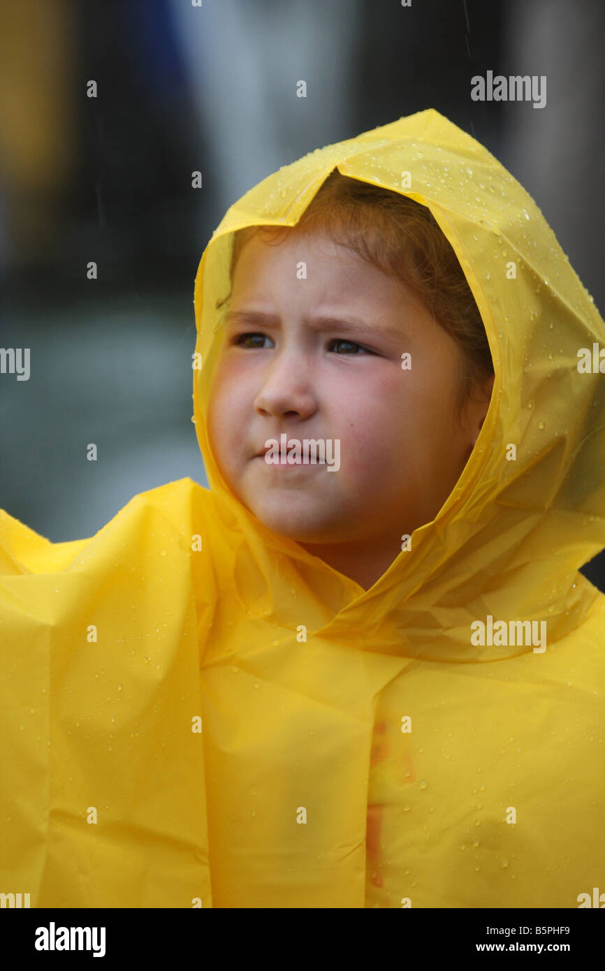 Ein kleines Kind in einen gelben Regenponcho oder eine Jacke Stockfoto
