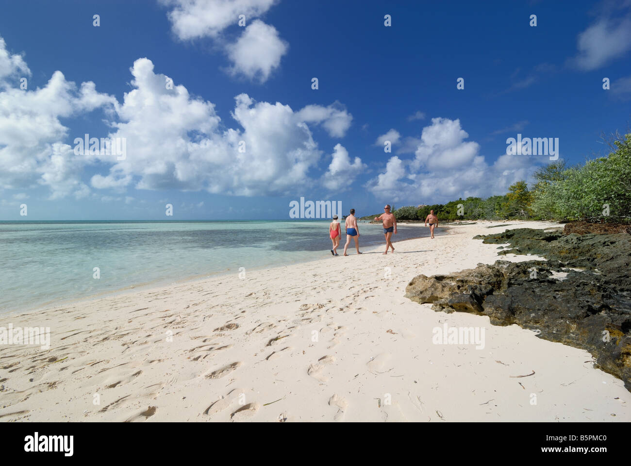 Urlauber Fuß den Strand von Little Stirrup Cay, Bahamas - eines der Berry-Inseln - eine Sammlung von Inseln und Inselchen. Stockfoto