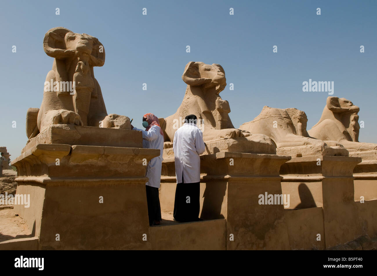 Arbeitnehmer Reinigung Linie ram vorangegangen Statuen am Prozessionsweg Sphingenallee auf der Karnak Tempel Komplex in der Nähe von Luxor Ägypten Stockfoto