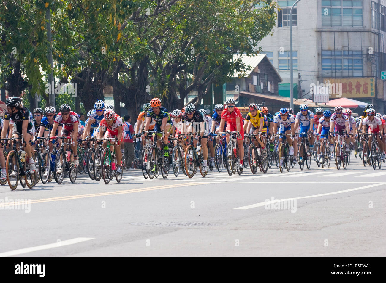 Im Hauptfeld Radfahrer vorbei an Massen, Tour de Taiwan Stufe 1 Crtierium, Kaohsiung, Taiwan, ROC Stockfoto