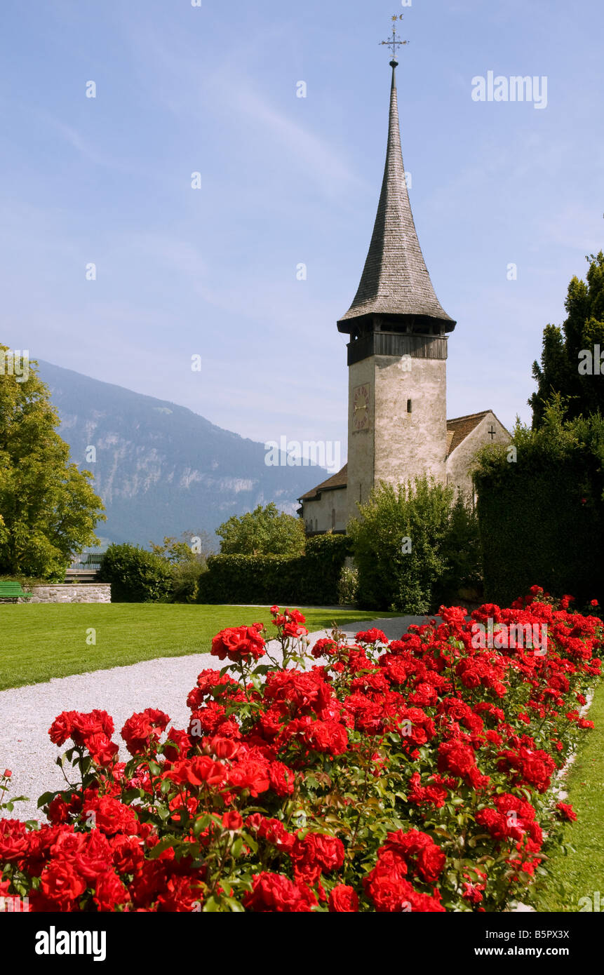 Die romanische Kirche neben dem Schloss Spiez angesehen von den formalen Gärten des Schlosses Stockfoto