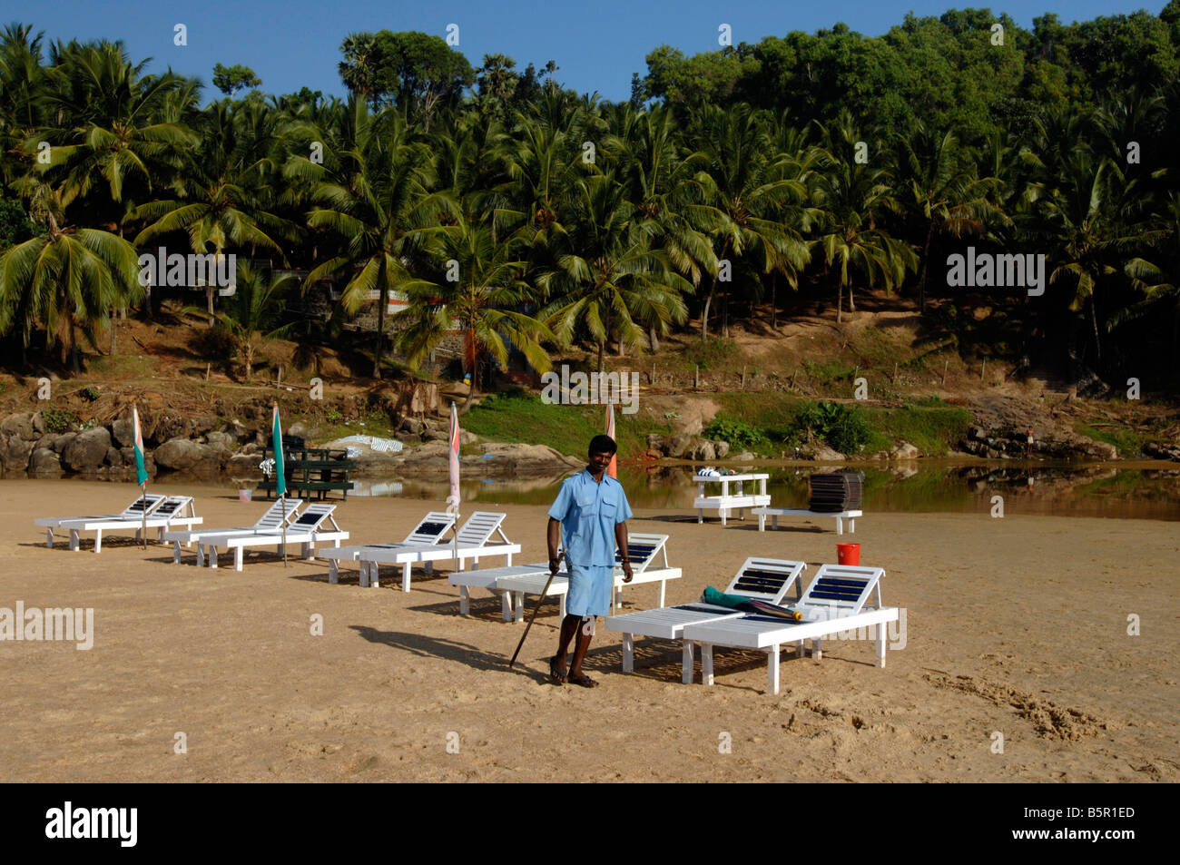 Mitglied Hotel Personal bereitet liegen für Touristen, die in der Anlage unter den Kokospalmen am Strand von Chowara, Kerala Stockfoto