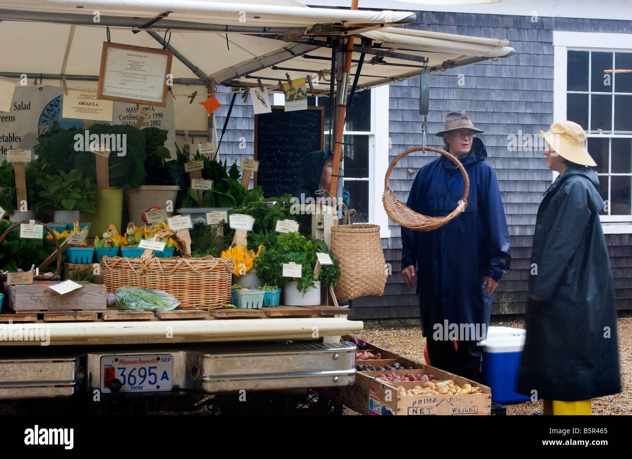 Zwei Produkte-Anbieter stehen im Regen auf einem Bauernmarkt auf Martha's Vineyard in Massachusetts. Stockfoto