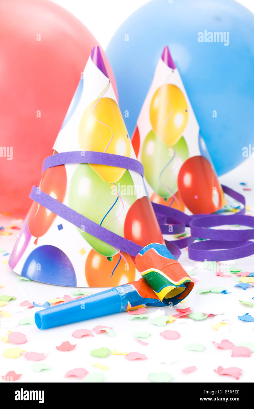 Partyhüte, Hörner oder Pfeifen, Confettis und Luftballons auf weißem Hintergrund. Stockfoto