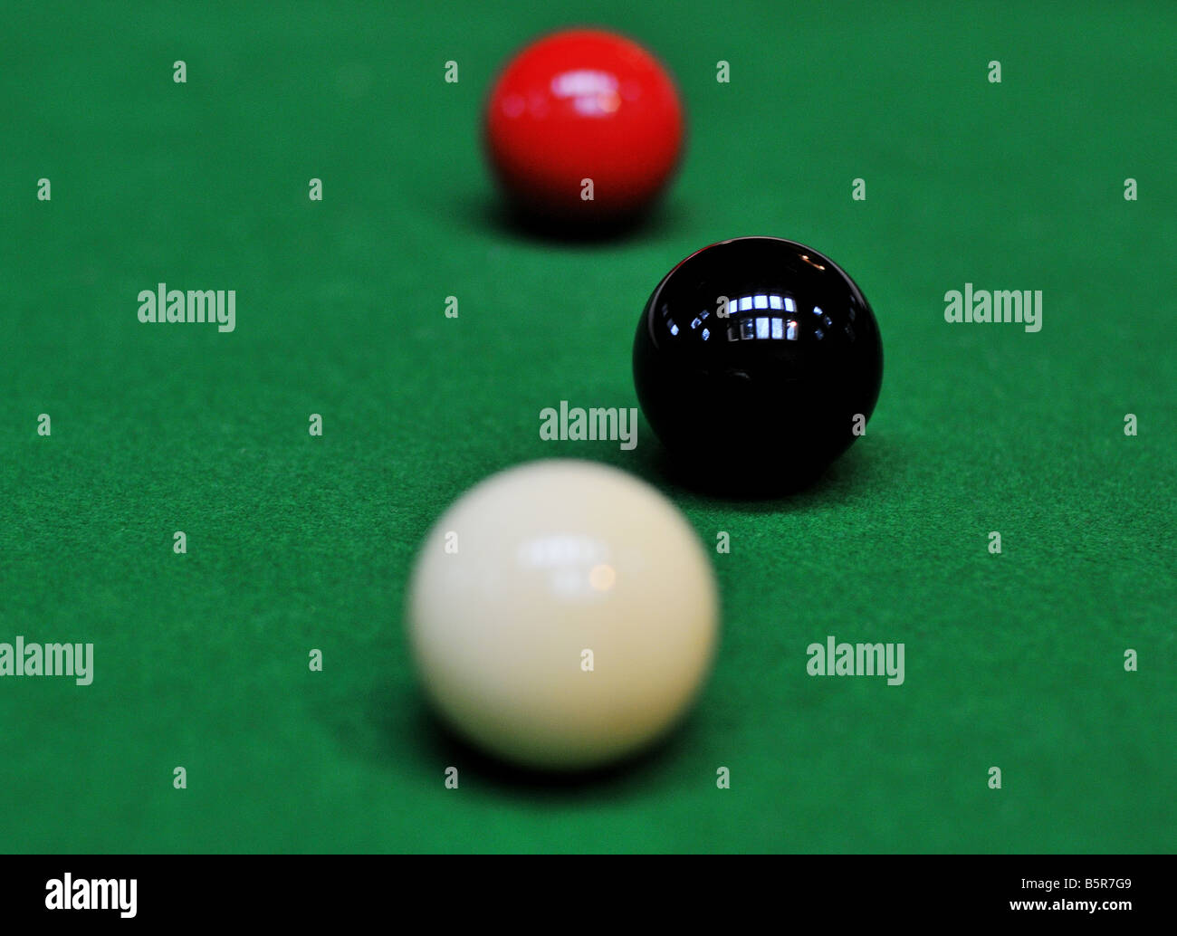 Pool-Billard-Kugeln aufgereiht, die weiße Kugel hinter die schwarze Kugel, die grünen Filz wie ein Teppich Gras gesnookert. Stockfoto