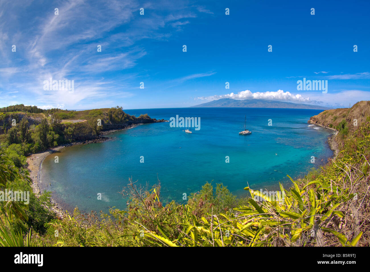Segelboote und Schnorchler in Honolua Bay, Maui, Hawaii. Das östliche Ende der Insel Molokai ist im Hintergrund. Stockfoto