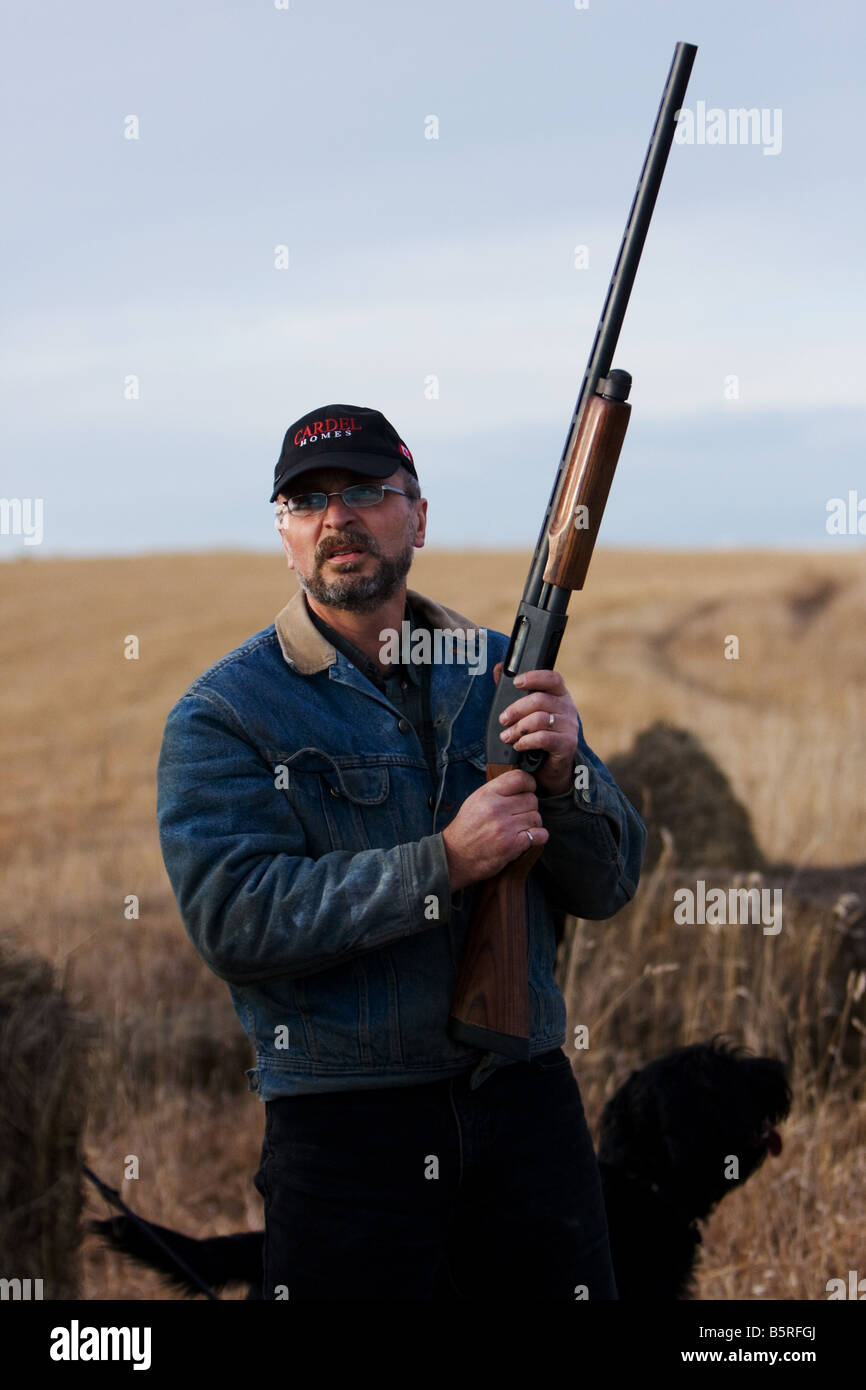 Mann mit einem Gewehr in einem Feld. Stockfoto
