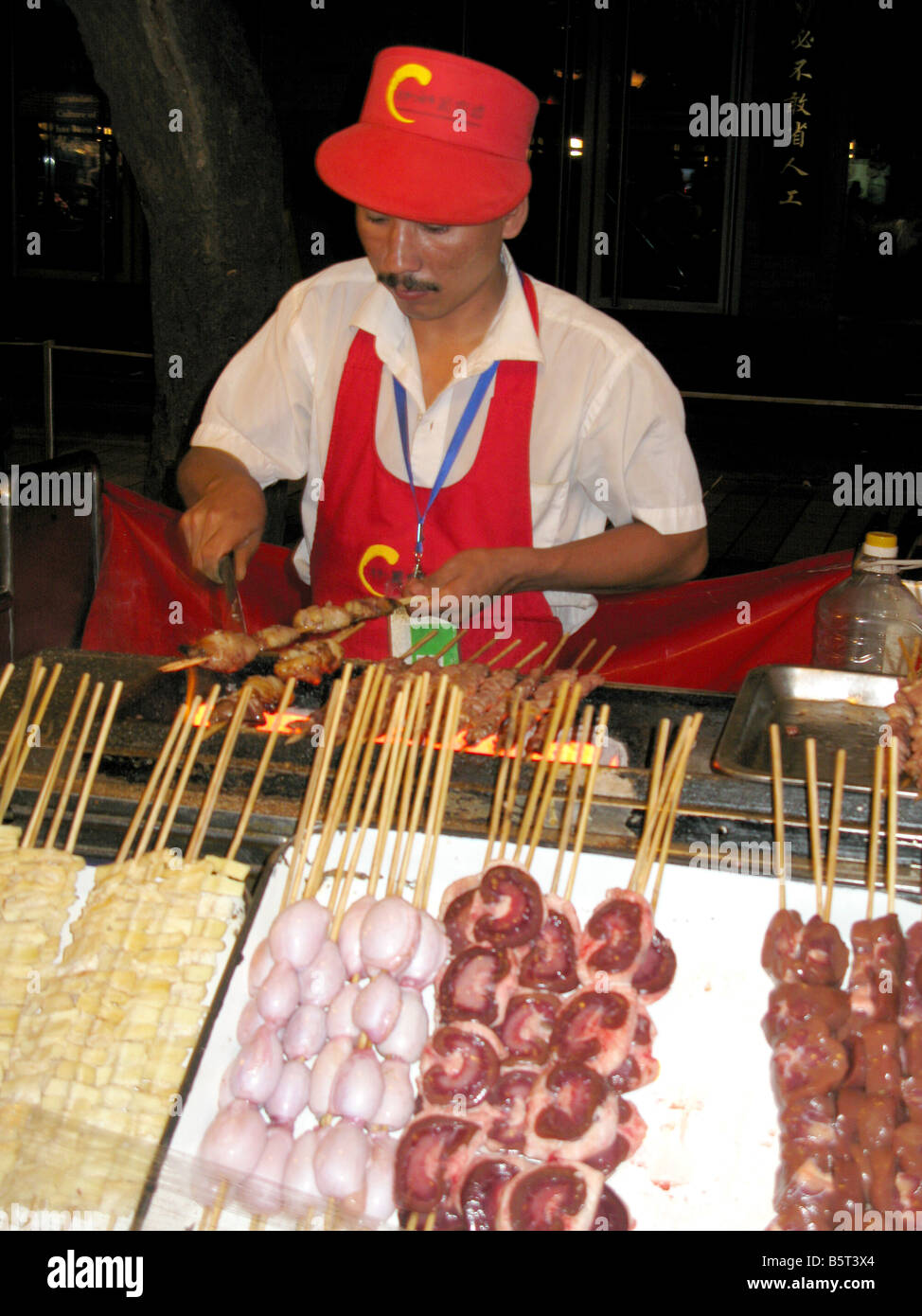 Ein Arbeiter auf der Donghuamen Night-Food Straßenmarkt in Peking China Stockfoto