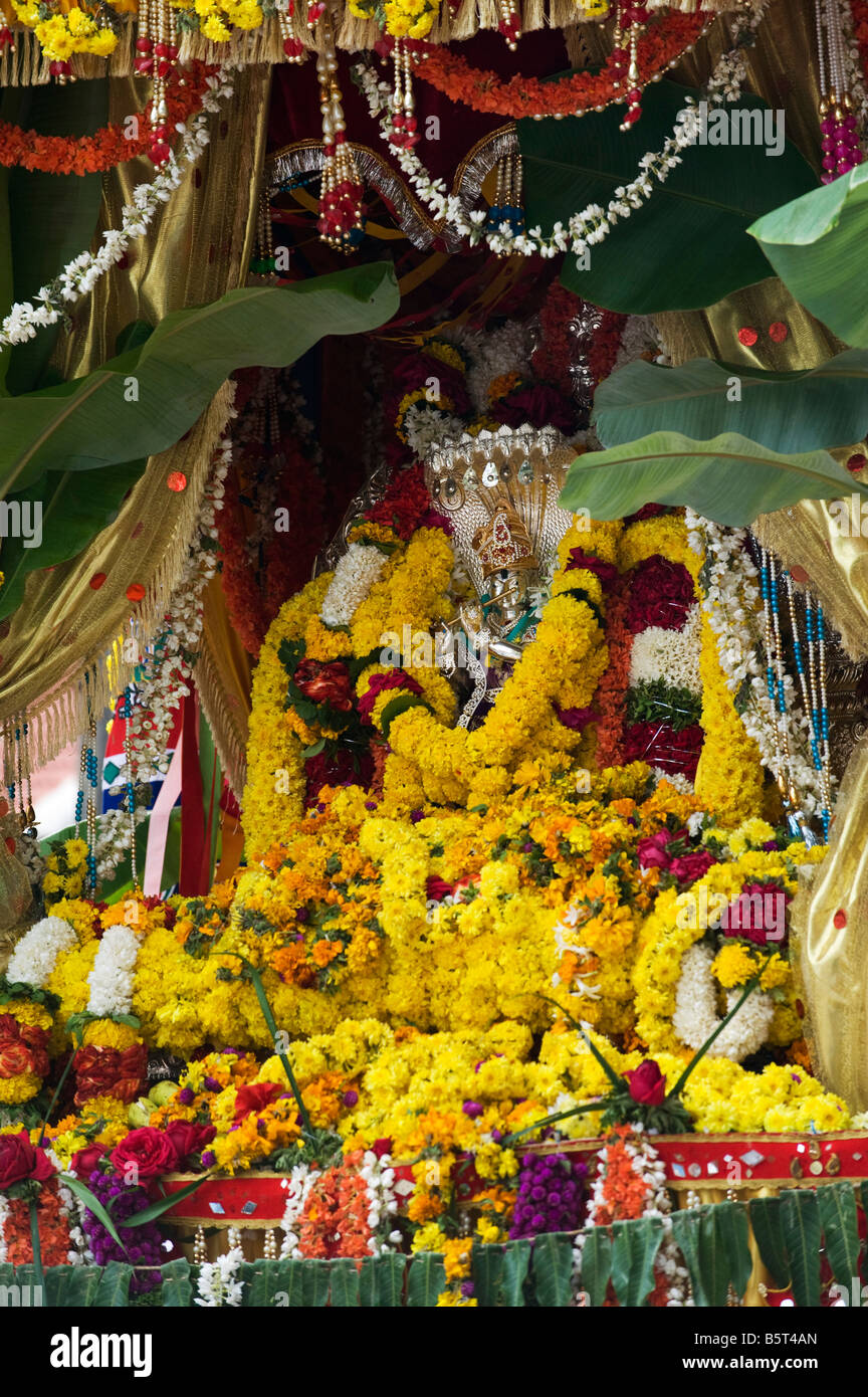 Lord Krishna Silberstatuen bekränzt an ein Hindu fest.  Puttaparthi, Andhra Pradesh, Indien Stockfoto