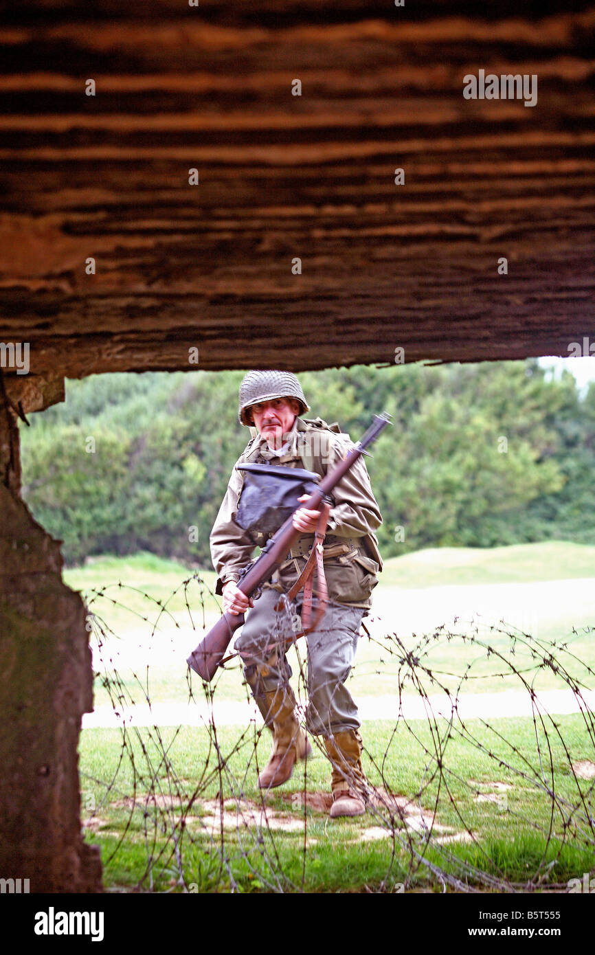 Schauspieler verkleidet als ein D Tag U.S.Ranger Sturm auf einen deutschen Bunker eine Pointe du Hoc, Normandie, Frankreich Stockfoto