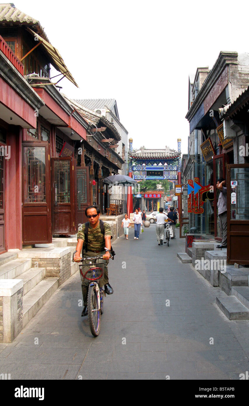 Ein Mann fährt Fahrrad durch die schiefe Tabakbeutel Straße Hutong in Peking Yandai Xiejie Stockfoto