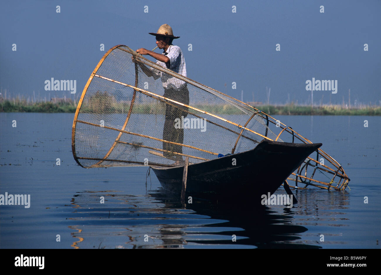 Ein Intha Bein Rudern Fischer mit seinem Boot und Cone-Shaped Net am Inle-See, Burma bzw. Myanmar Stockfoto