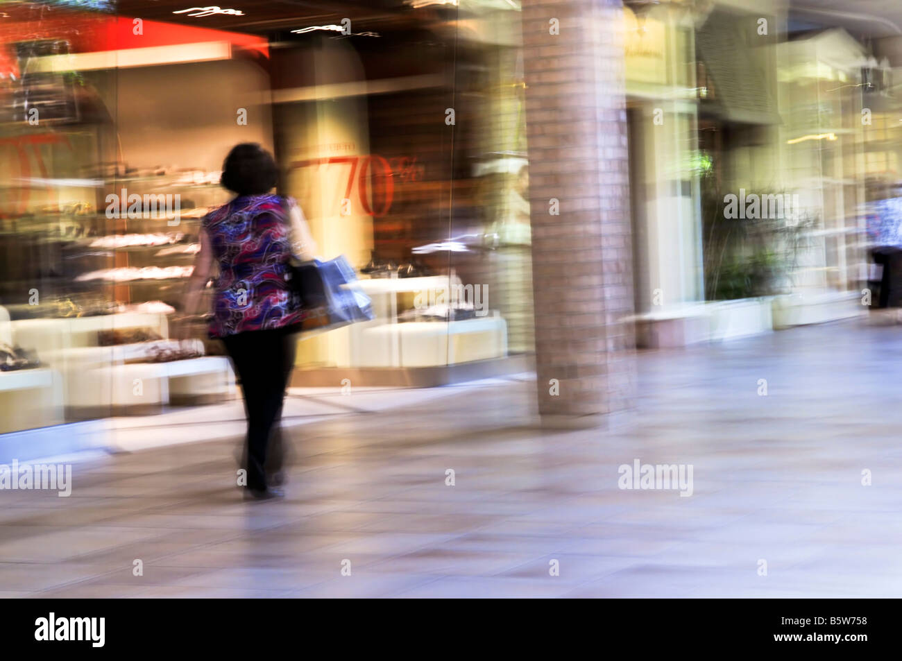 Frau shopping in einem Einkaufszentrum Schuss absichtlich in der Kamera schwenken Bewegungsunschärfe Stockfoto