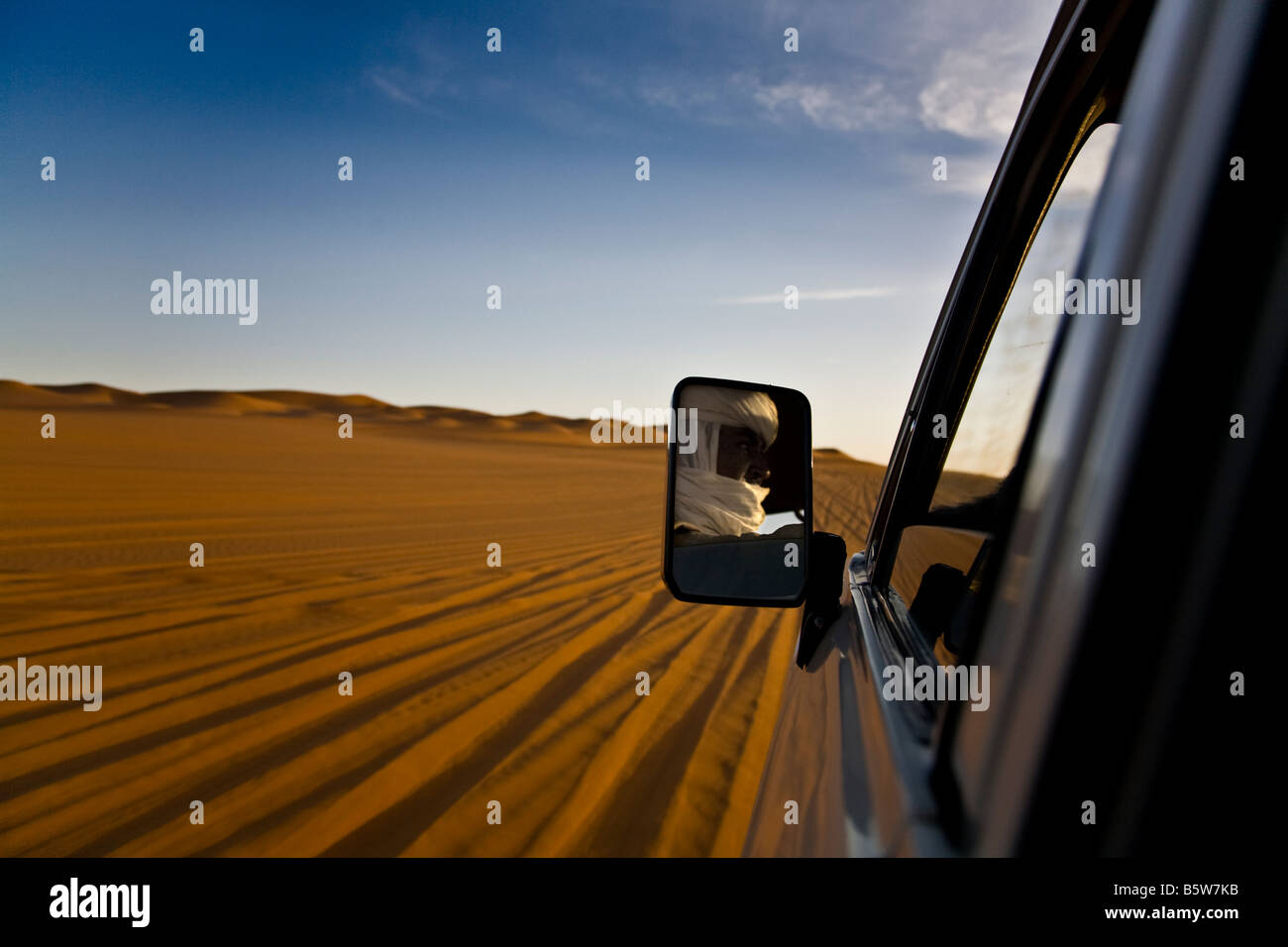 Ein Tuareg Bild spiegelt sich in den Spiegel ein Toyota Land Cruiser in den Idhan Ubari, ein Teil der Sahara in Libyen. Stockfoto