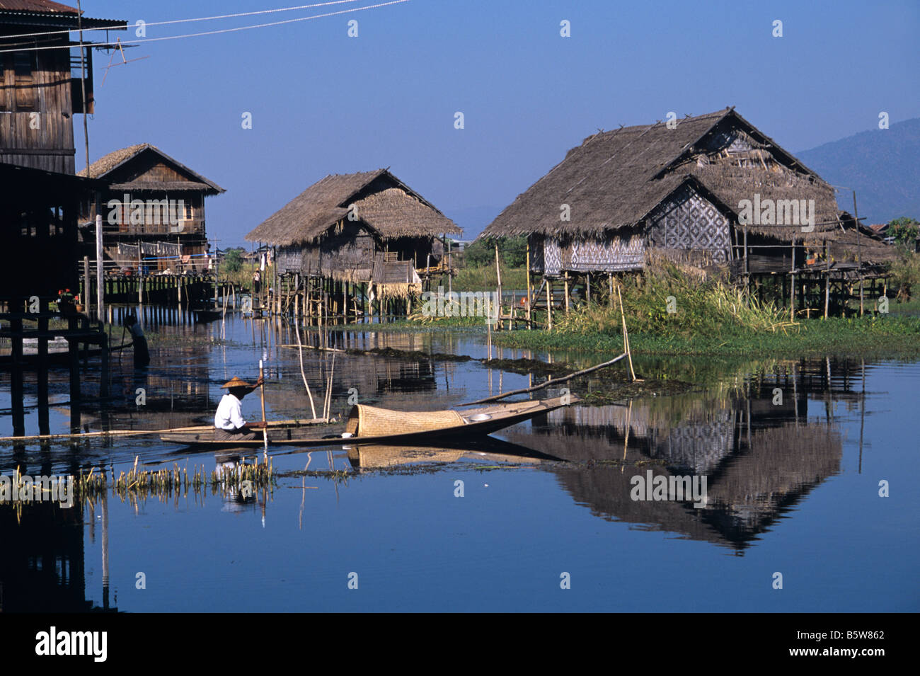 Ein burmesische Intha-Mann Kanu Vergangenheit Pfahlbauten am Inle See, zentrale Burma bzw. Myanmar beherbergt Stockfoto