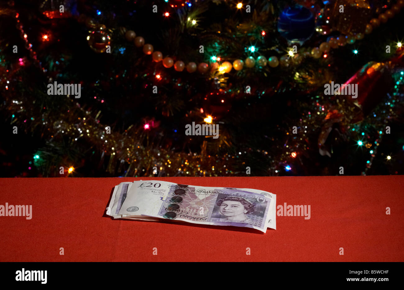Haufen von zwanzig Pfund Sterling Pfund vor Weihnachtsbaum Stockfoto
