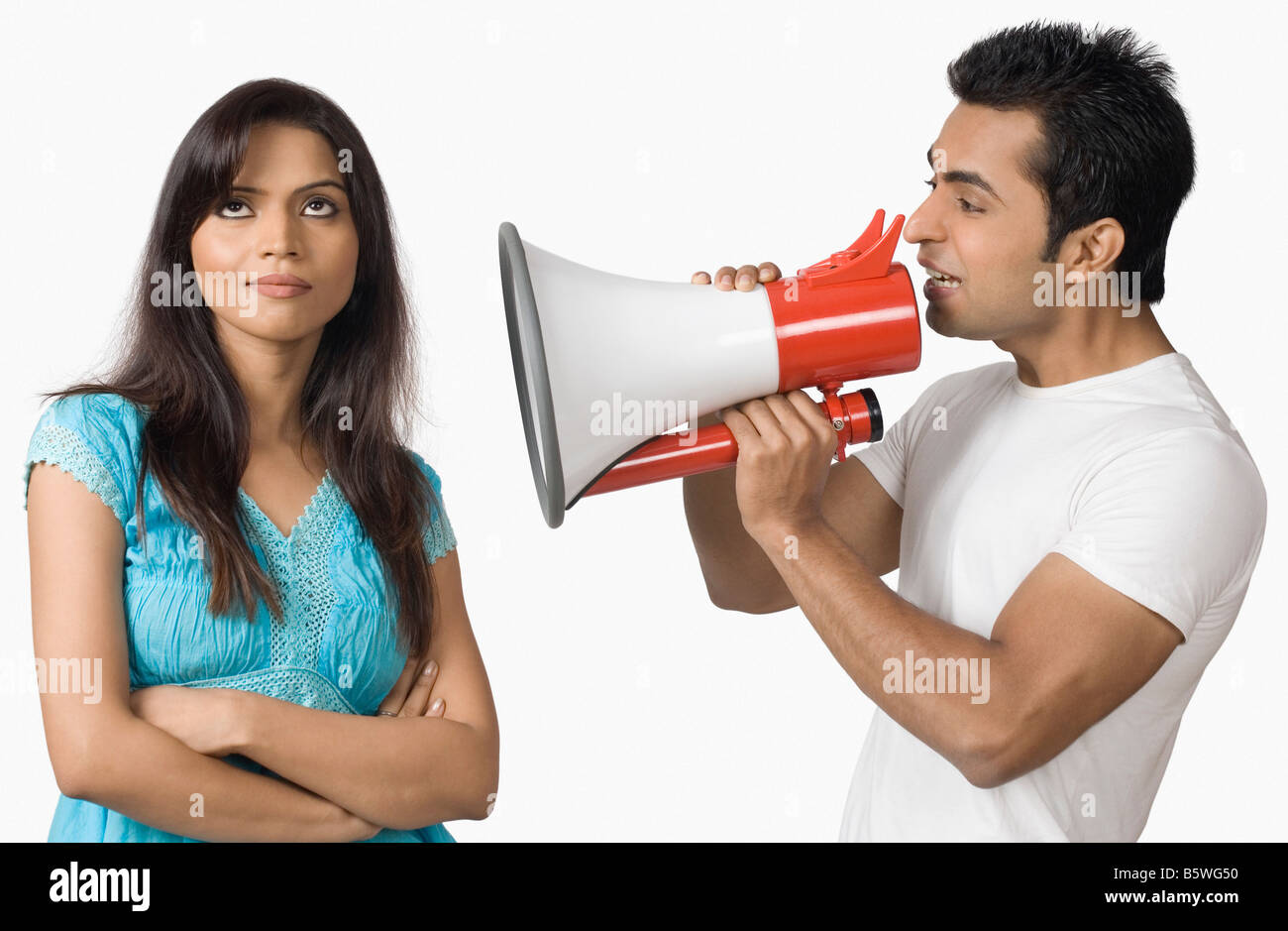 Seitenansicht eines jungen Mannes bläst ein Megaphon mit einer Teenager-Mädchen neben ihm stehenden Stockfoto