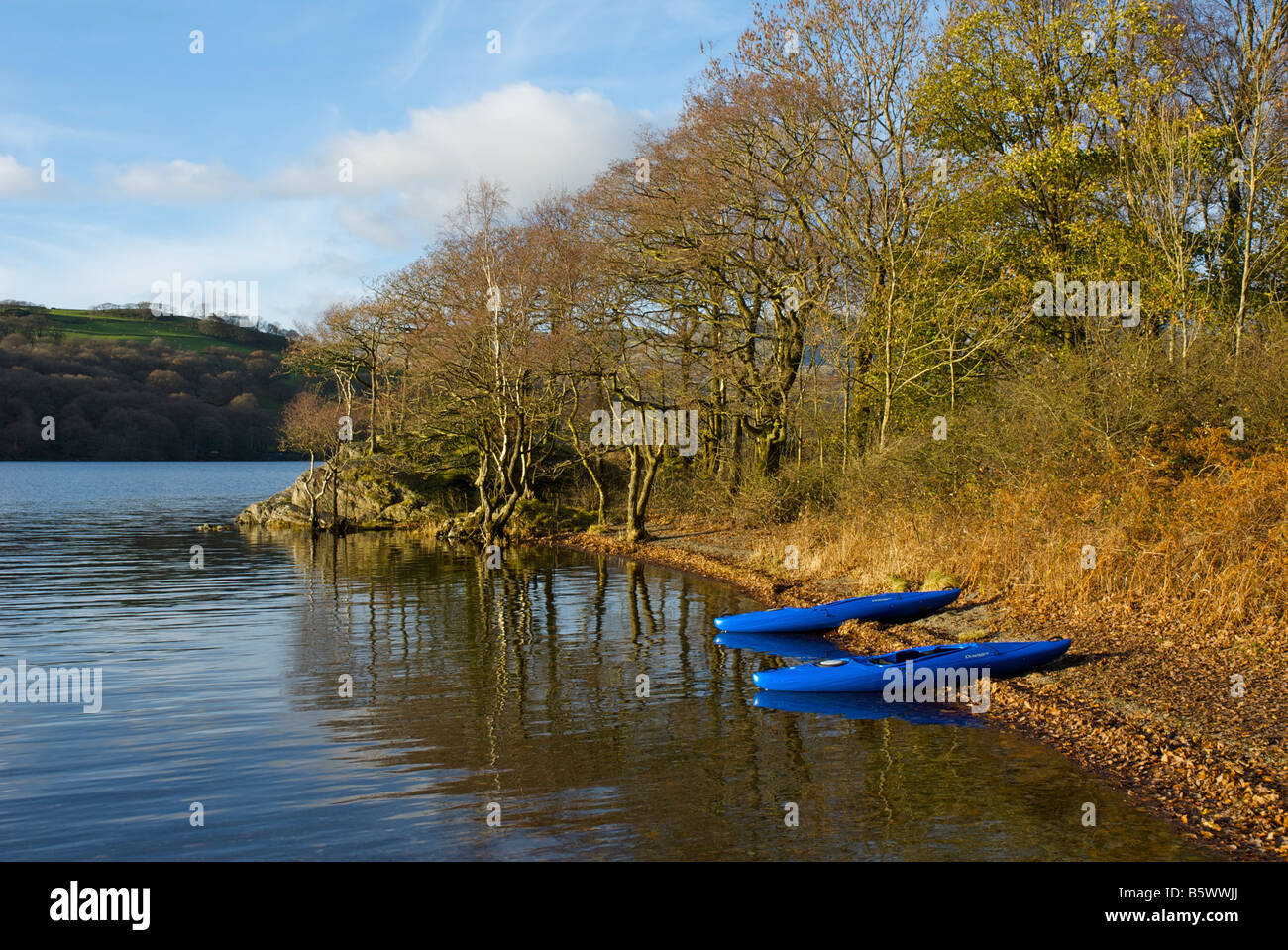 Zwei blaue Kanus auf einem Strand, Coniston See, Lake District National Park, Cumbria, England UK gezogen Stockfoto