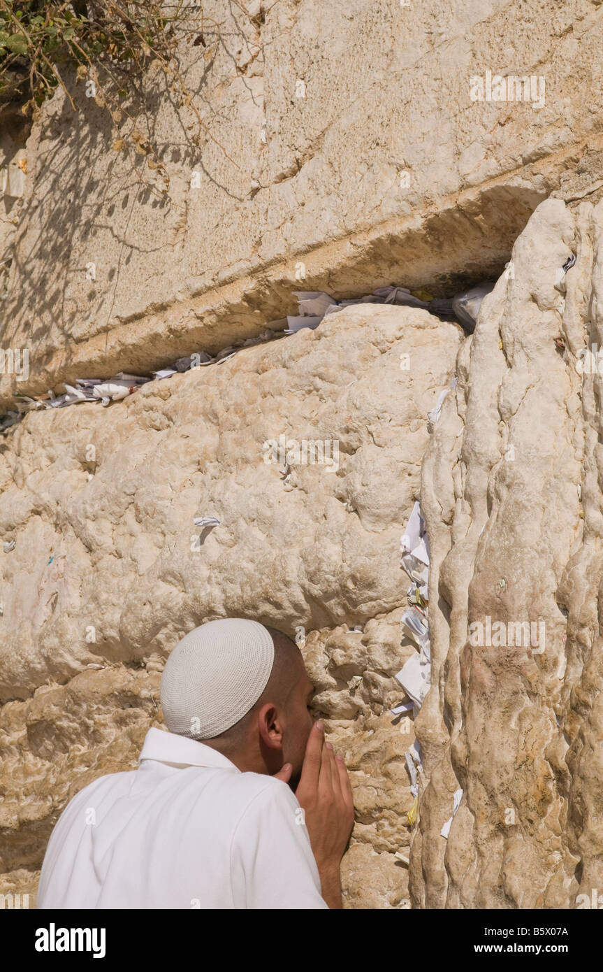 Israel Jerusalem westlichen Altstadtmauer junger Mann in weiß küssen die Wand in Ehrfurcht mit Noten in Rissen Stockfoto
