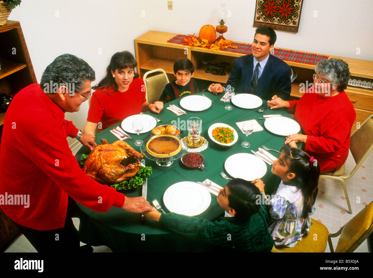 Hispanische Familie betet vor Thanksgiving-Dinner. Stockfoto