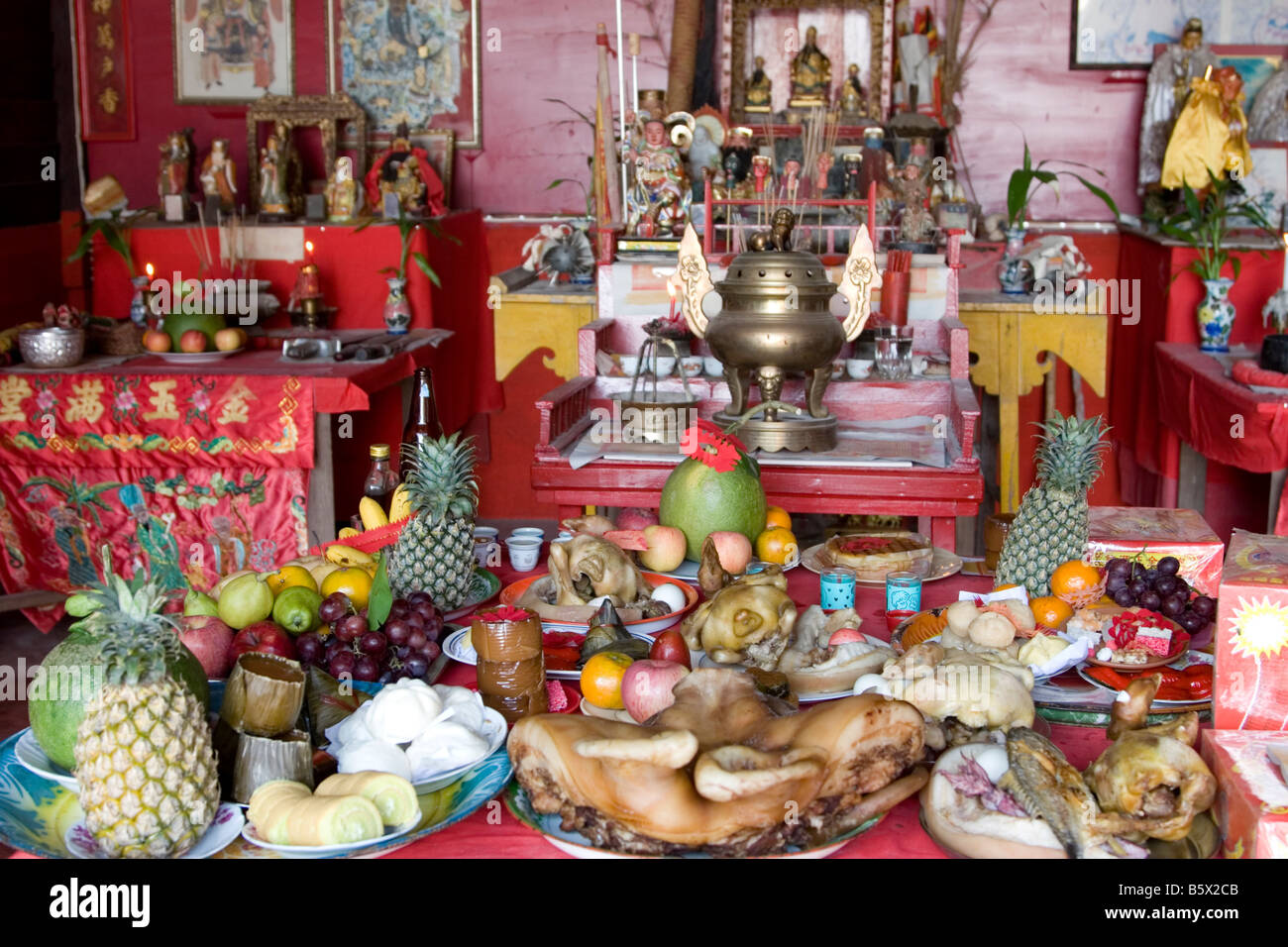 Tisch voll mit Lebensmittel-Angebote in einem chinesischen Tempel in Thailand. Stockfoto