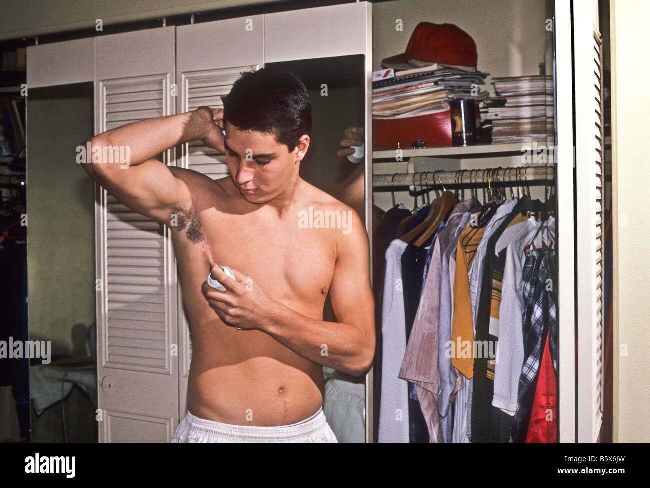 Männliche Teenager gilt Deodorant für Achselhöhlen. Stockfoto
