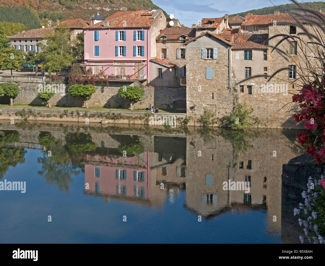 Fluss Aveyron mit verschiedenen Häusern Farbe rosa mit Reflexion am Fluss Saint Antonin Noble Val Midi-Pyrenäen Stockfoto