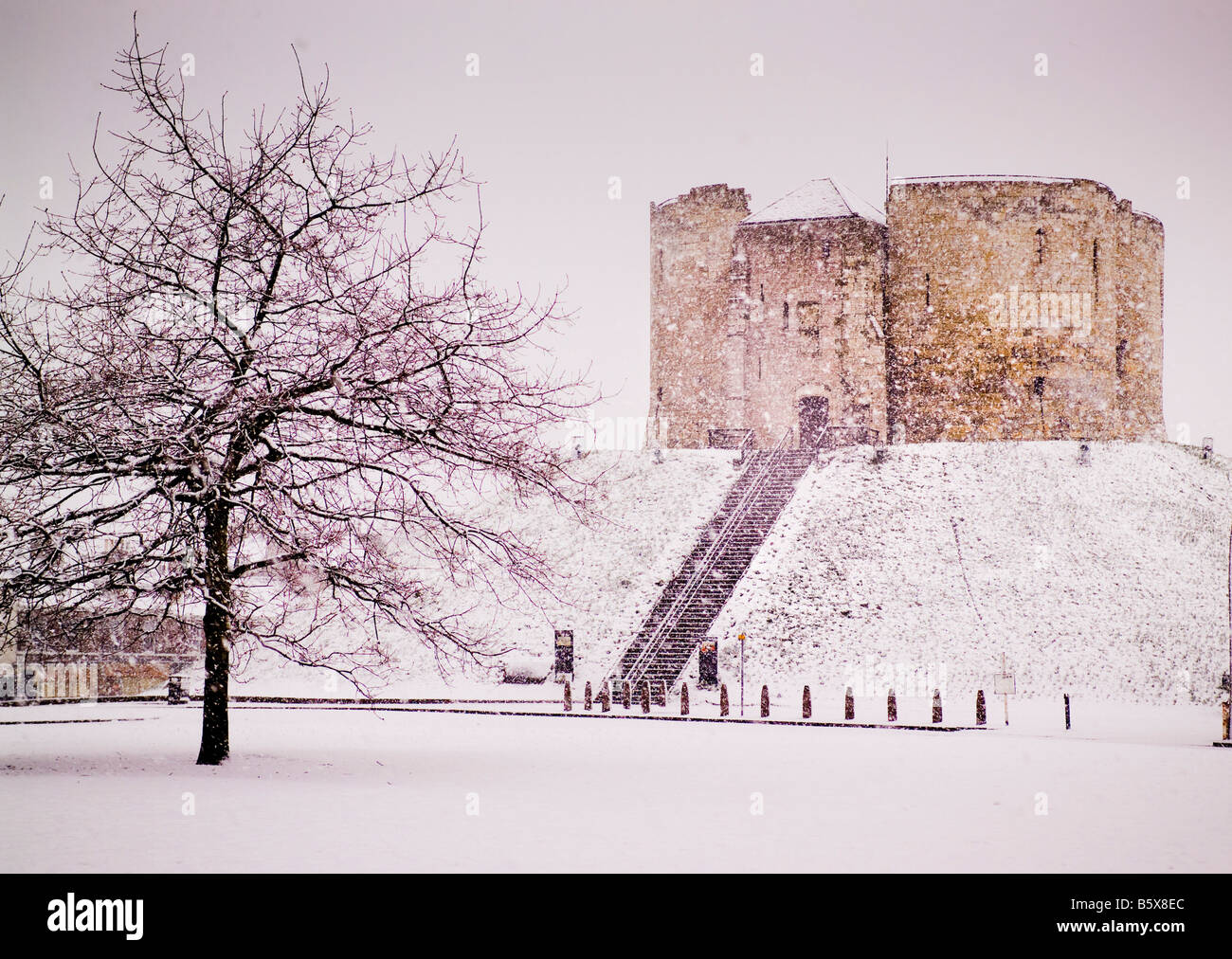 Cliffords Tower York in einer Schneeschauer mit dem Auge von York im Vordergrund. UK Stockfoto