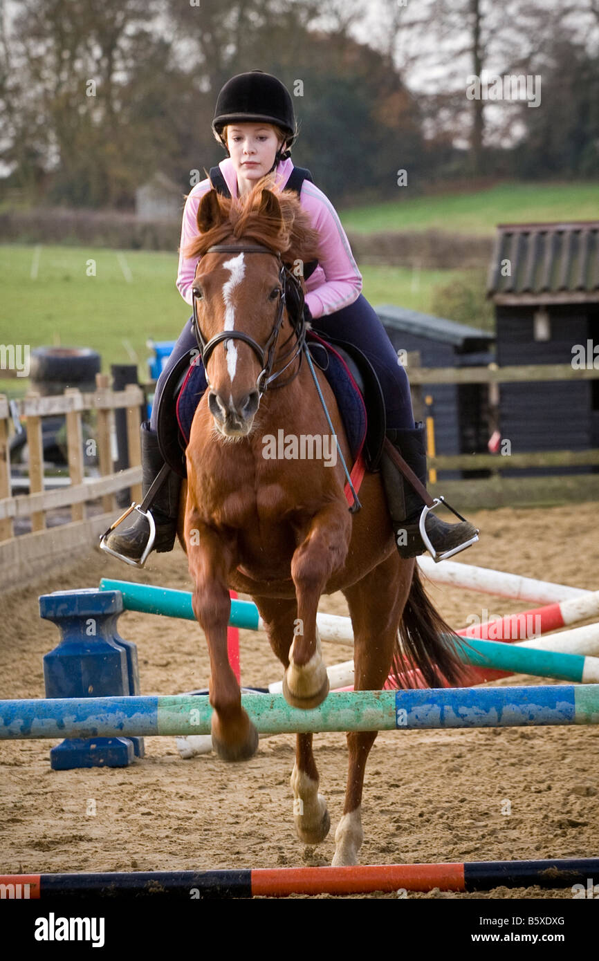 Teenager-Mädchen ihr Pony reiten Stockfoto