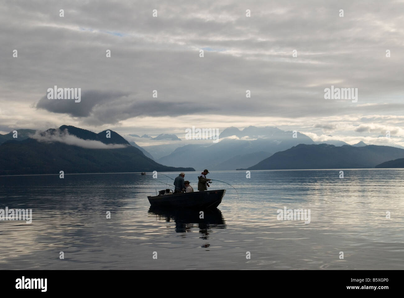 Lachs Fischer aus Ravencroft Lodge am Hafen Fidalgo Inlet, Alaska Fisch für Silberlachs an einem ruhigen, bewölkten Morgen. Stockfoto