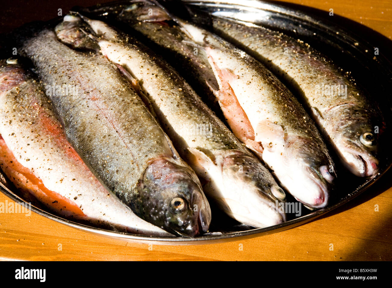Fünf frische Forellen auf einem silbernen Tablett Stockfoto