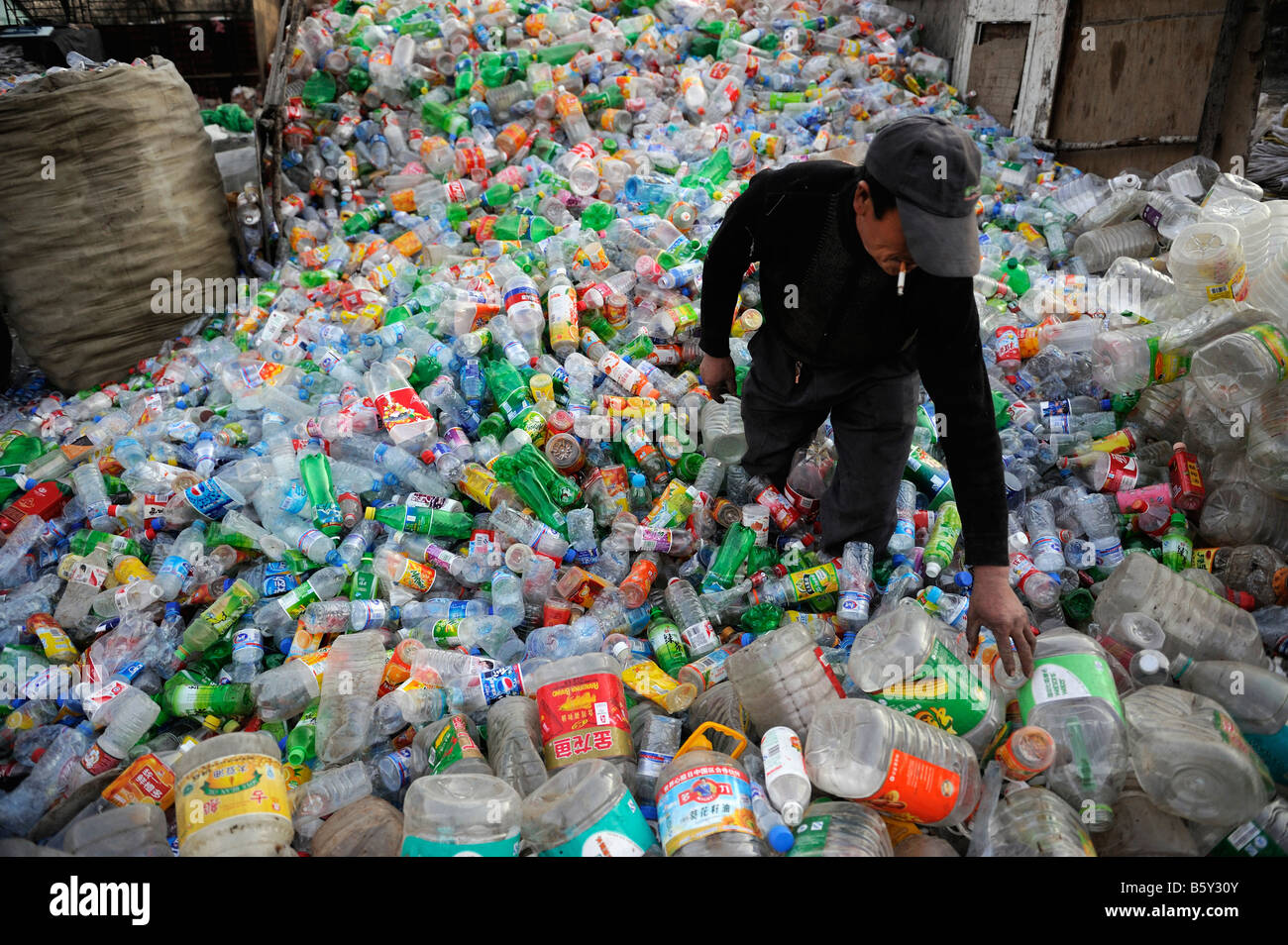 Chinesischer Mann sammelt Kunststoff Flaschen an eine Recyclingstation Stadtrand von Peking, China. 20. November 2008 Stockfoto