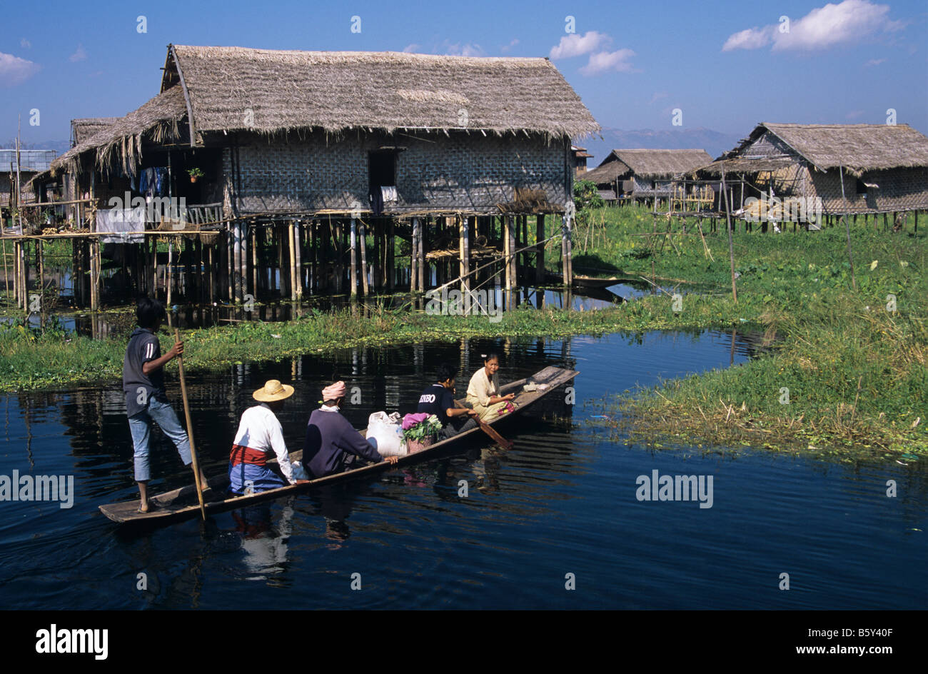 Eine burmesische Familie kehrt mit dem Kanu in ihrem Stelzenhaus am Inle-See, Burma bzw. Myanmar Stockfoto