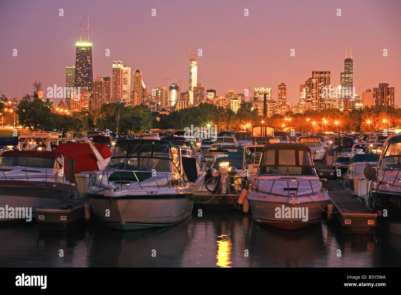 Boote mit Skyline der Stadt beleuchtet in einer Sommernacht in Chicago Illinois in der Marina am Diversy Hafen angedockt. Stockfoto